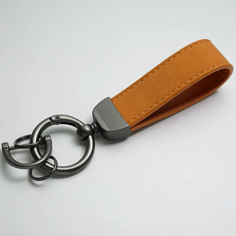 Brown leather keychain with metal keyring on a light gray background
