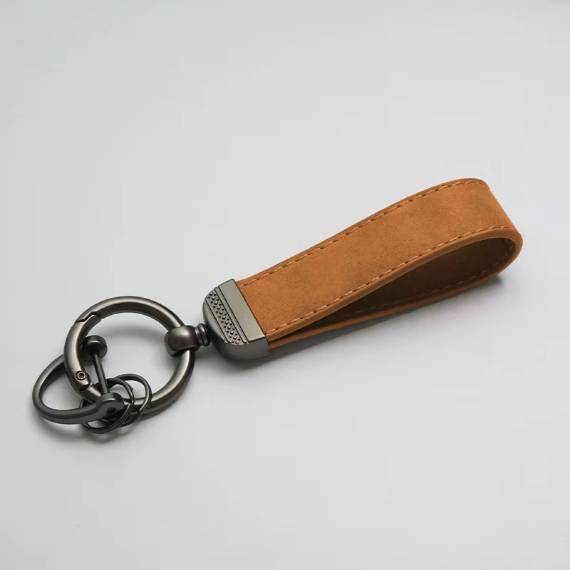 Brown leather keychain with metal ring on a light gray background