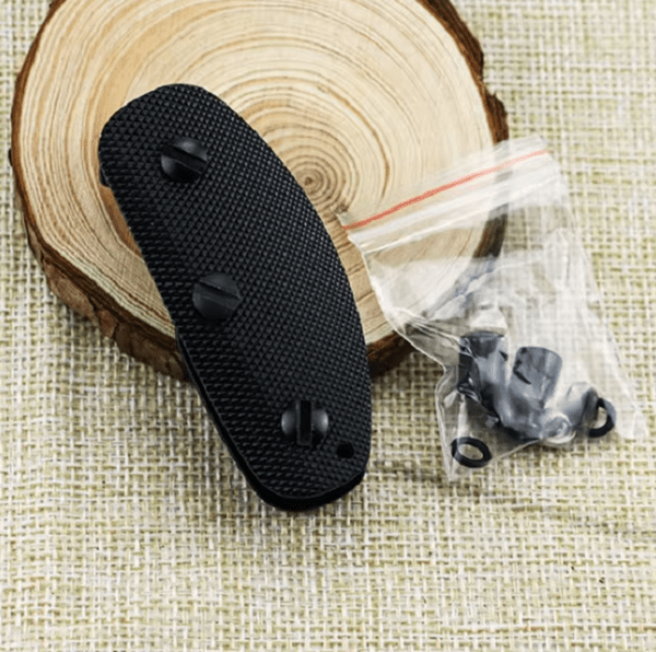 Black Key Holder with screws on wood background.
