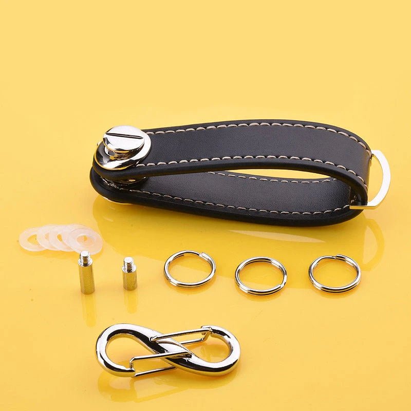 Black leather keychain with metal components on a yellow background