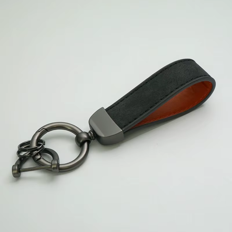 Black leather keychain with metal ring on a light gray background
