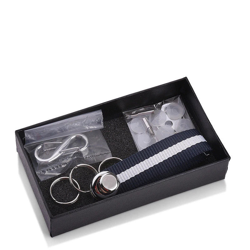 Metal components and blue and white striped nylon key organizer in black box on a white background.
