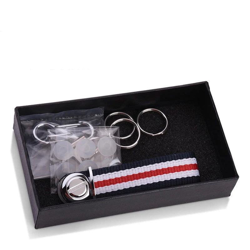 Metal components and striped nylon key organizer in black box on a white background.