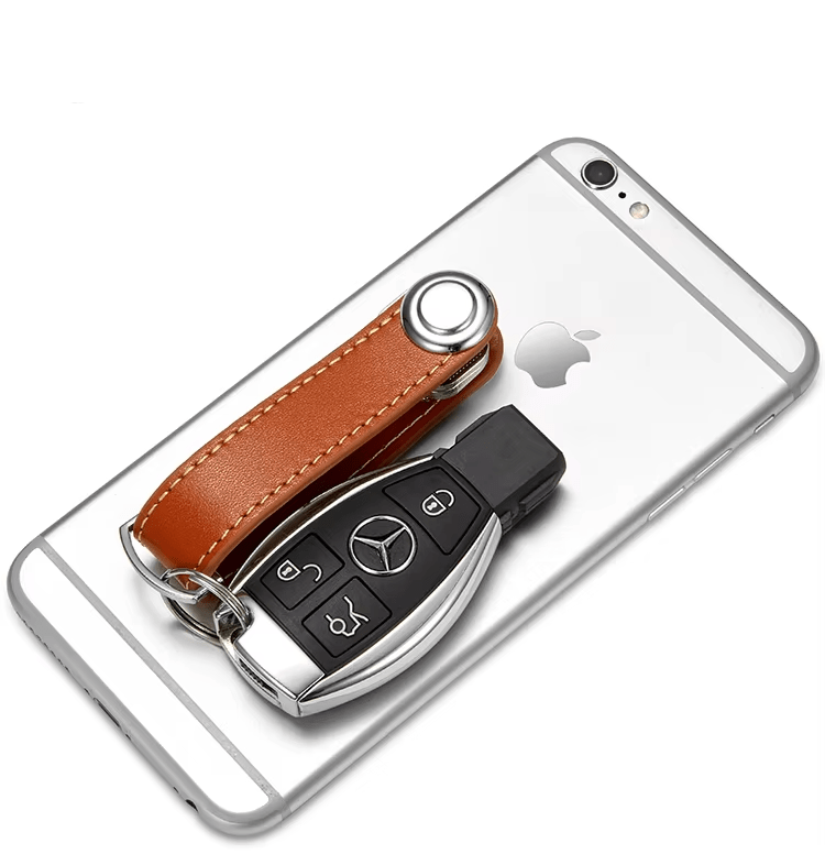 Brown leather key organizer on a Phone case with Mercedes-Benz car key on a white background.