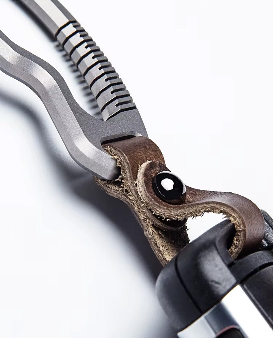 Close-up of titanium carabiner with brown leather strap connection