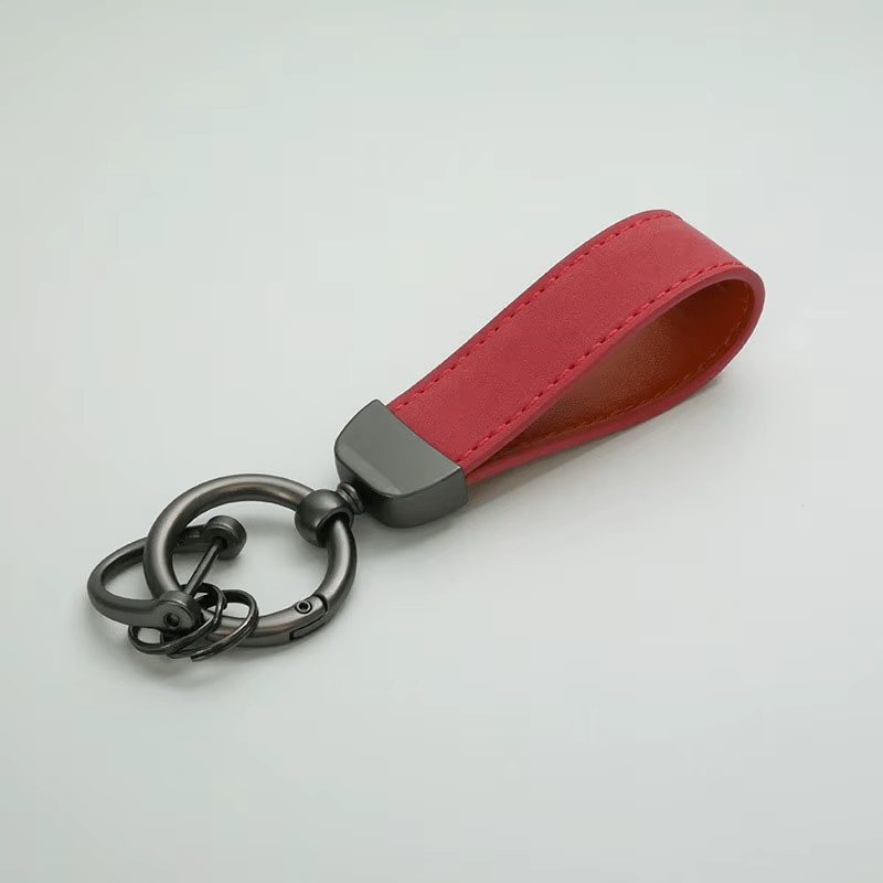 Red leather keychain with black metal ring on a light gray background