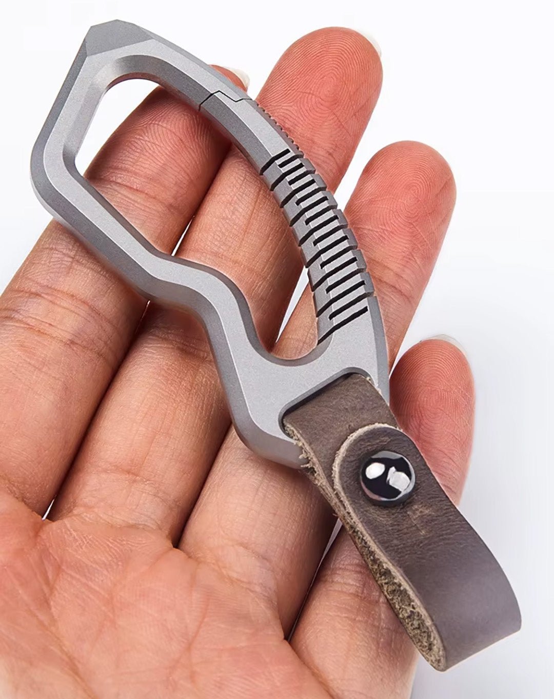 Hand holding titanium carabiner with genuine leather loop