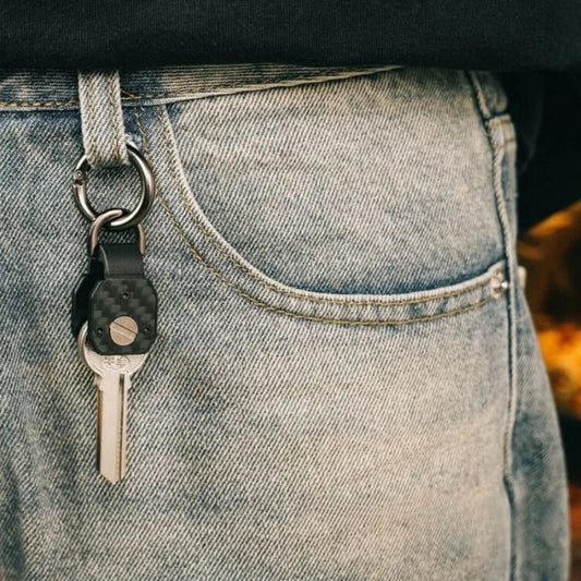 Keychain with a key attached to a person's jeans pocket.