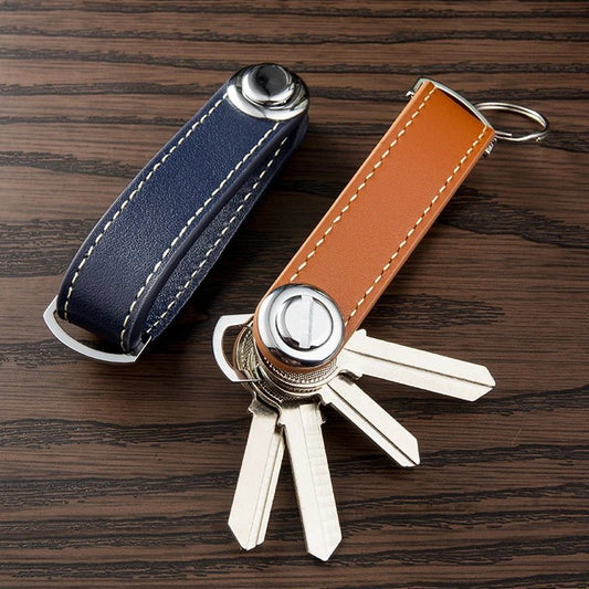 Key organizer with blue and brown leather straps on a wooden surface