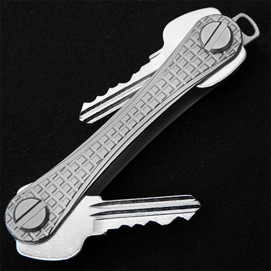 Metallic key organizer with keys on a black background