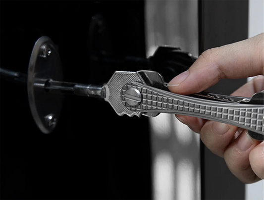 Hand holding a silver multitool against a dark background