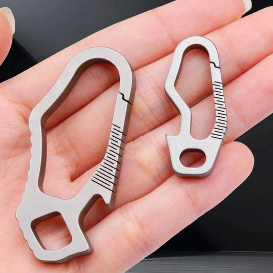 Hand holding small and large titanium carabiners side by side